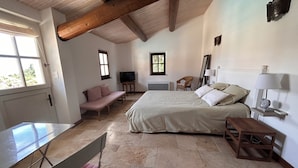 A bedroom with a bed, a chair, a table, and a TV. - Adorable house with  swimming pool and panoramic view (Villeneuve)