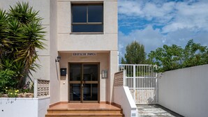 A building entrance with a sign reading "EDIFICIO POPEA" and a staircase leading up to it.