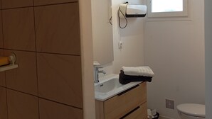 A bathroom with a white sink, mirror, and towel rack. There is a window with a view of the sky, and a toilet. - 5-minute walk from Aigre, 60m2 ground floor apartment (Aigre)
