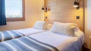 A double room with two beds, a wooden wall, and a window with curtains. - Luxury apartment spa & parking, Les Saisies, 11 people (Les Saisies)