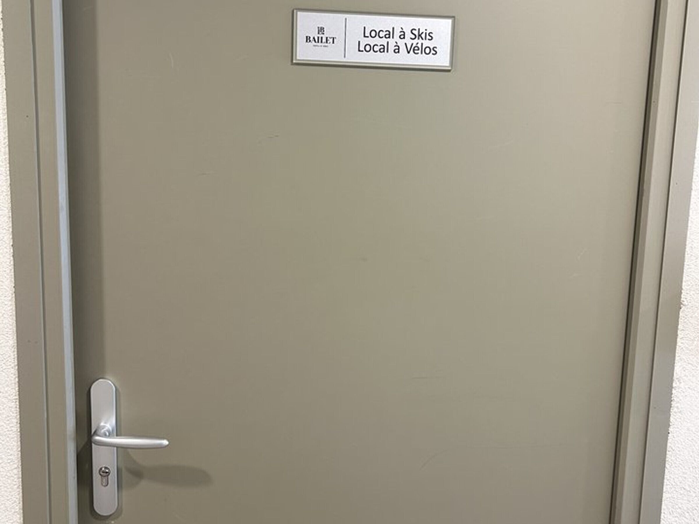 A door with a sign indicating directions to local ski and cycling facilities.