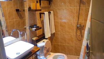 Un baño con lavamanos, inodoro y ducha.