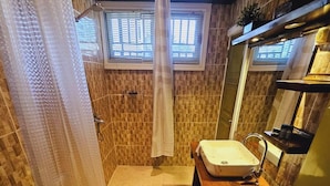 Un baño con ducha, inodoro y lavabo.
