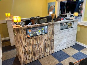 A reception desk with a wooden design, multiple computer monitors, and a check-in counter. - The Retreat (Yaoundé)
