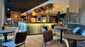 Un intérieur moderne avec un bar, des espaces de détente et une plante décorative.