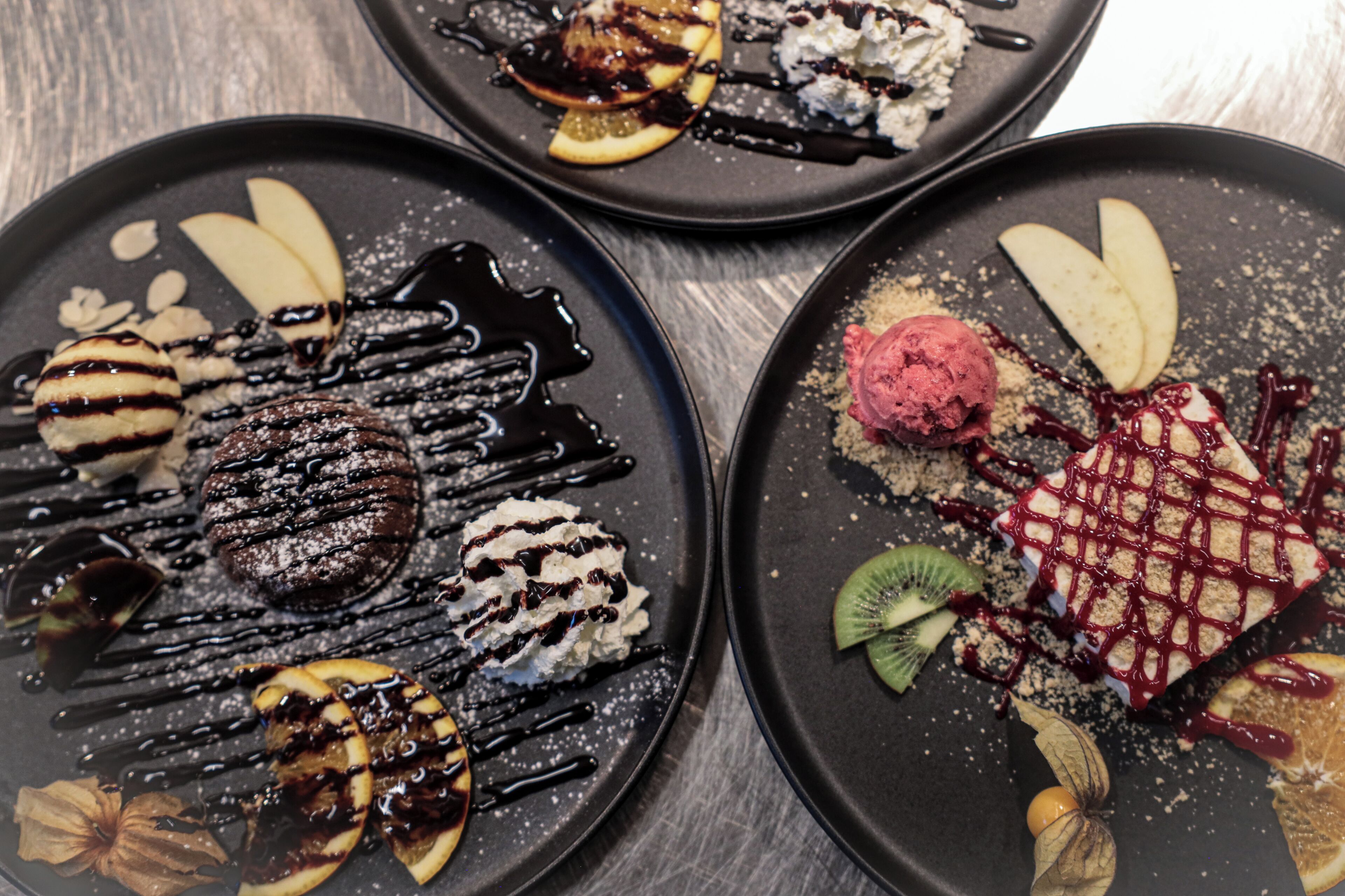 Three dessert plates with various toppings and garnishes.