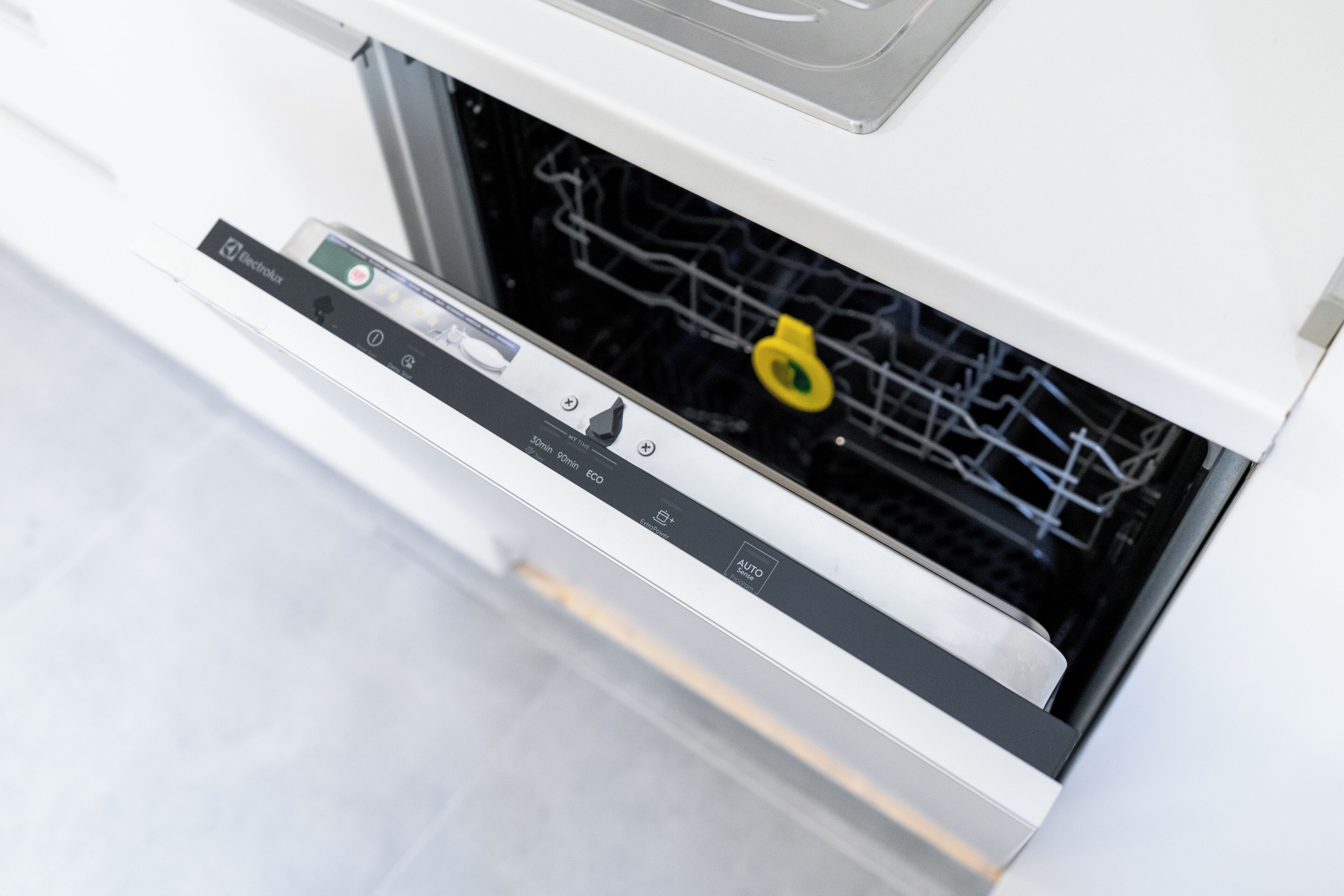 Un electrodoméstico blanco con un panel de control y un objeto circular amarillo en su interior.