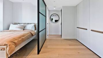 Un dormitorio con cama, mesita de noche, espejo y armario.