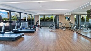 Et moderne fitnesscenter med løbebånd, crosstrainere og træningsudstyr.