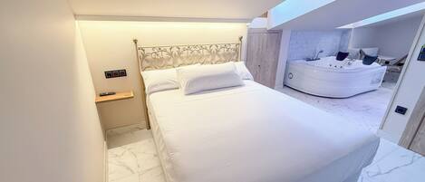 A modern bedroom with a large bed, a built-in jacuzzi, and a skylight.
