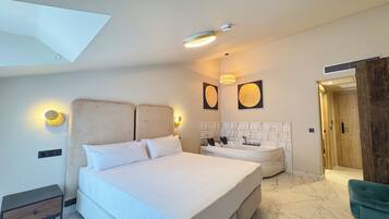 Un dormitorio moderno con una cama grande, una bañera integrada, un tocador y una puerta de madera.