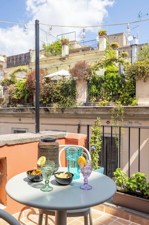 A round table with a glass pitcher, two bowls, and two glasses on a balcony. - Flower Terrace – Campo de’ Fiori
-  Panoramic terrace in the heart of Rome - (Roma)