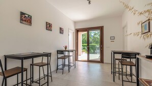 Una cuina moderna amb una illa central, tamboretes de bar i una taula de dinar.