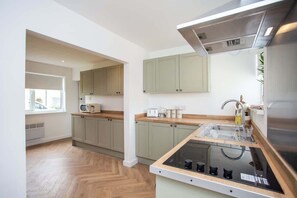 A modern kitchen with a central island, built-in cabinets, and a window providing natural light.