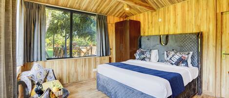 A wooden-paneled bedroom with a large bed, a window, and a view of the outdoors.