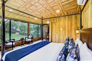 A spacious bedroom with a large bed, wooden ceiling, and a view of a garden. - Alaya Stays Fortezza | Pet-friendly 6-BHK Farmhouse With Private Pool (Sohna)