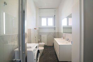 Een douche, een haardroger, een bidet, handdoeken