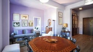 Un salon comprenant une table ronde en bois, un canapé et un coin repas avec des chaises.
