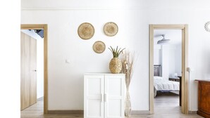 A room with a white cabinet, three woven wall hangings, a pineapple decoration, and a bed in the background. - A&N Yecla Torre del Mar (Torre del Mar)