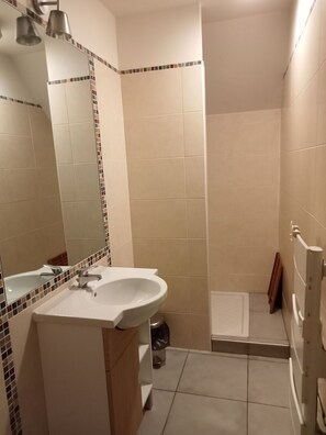 Un bagno con lavandino, specchio e zona doccia.