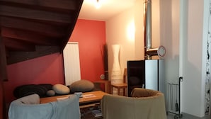 En hyggelig stue med sofa, lænestole, sofabord og pejs.