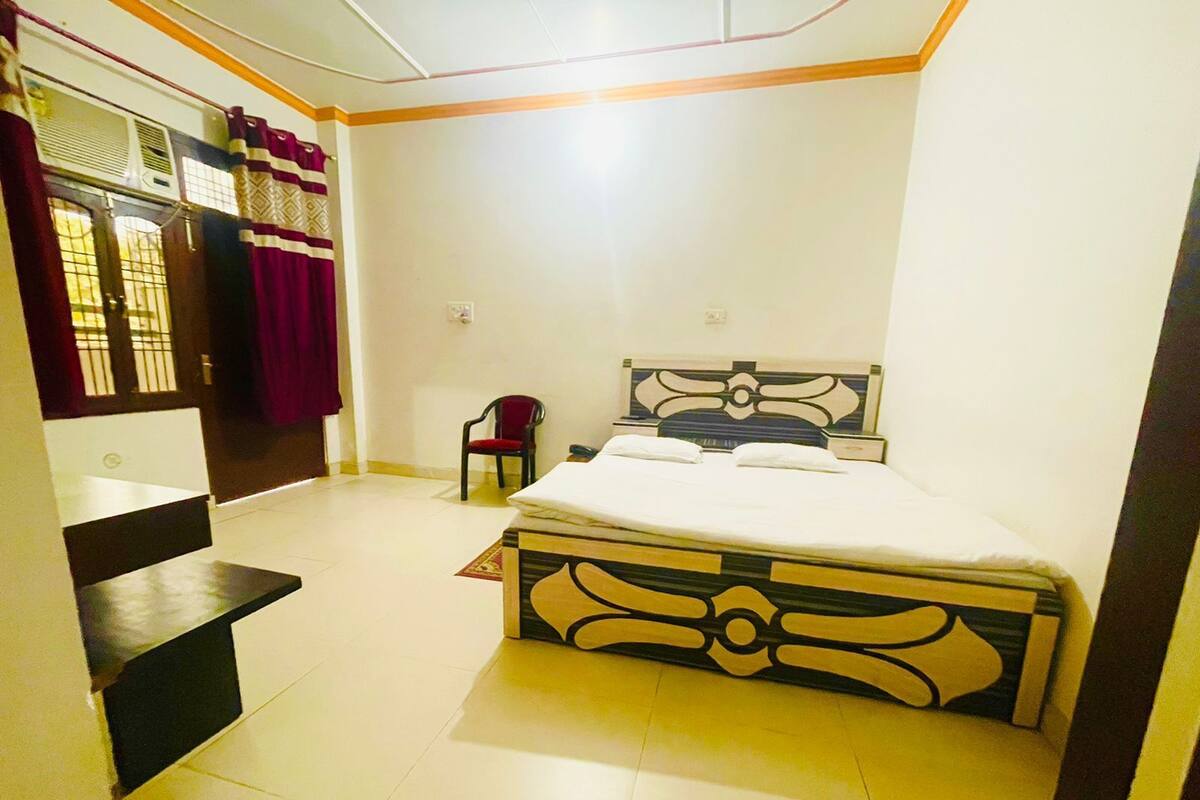 Une chambre à coucher comprenant un lit, une chaise et un escalier menant à un étage supérieur.