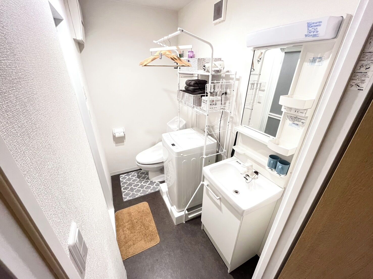 Ein kleines Badezimmer mit Toilette, Waschmaschine und Waschbecken.