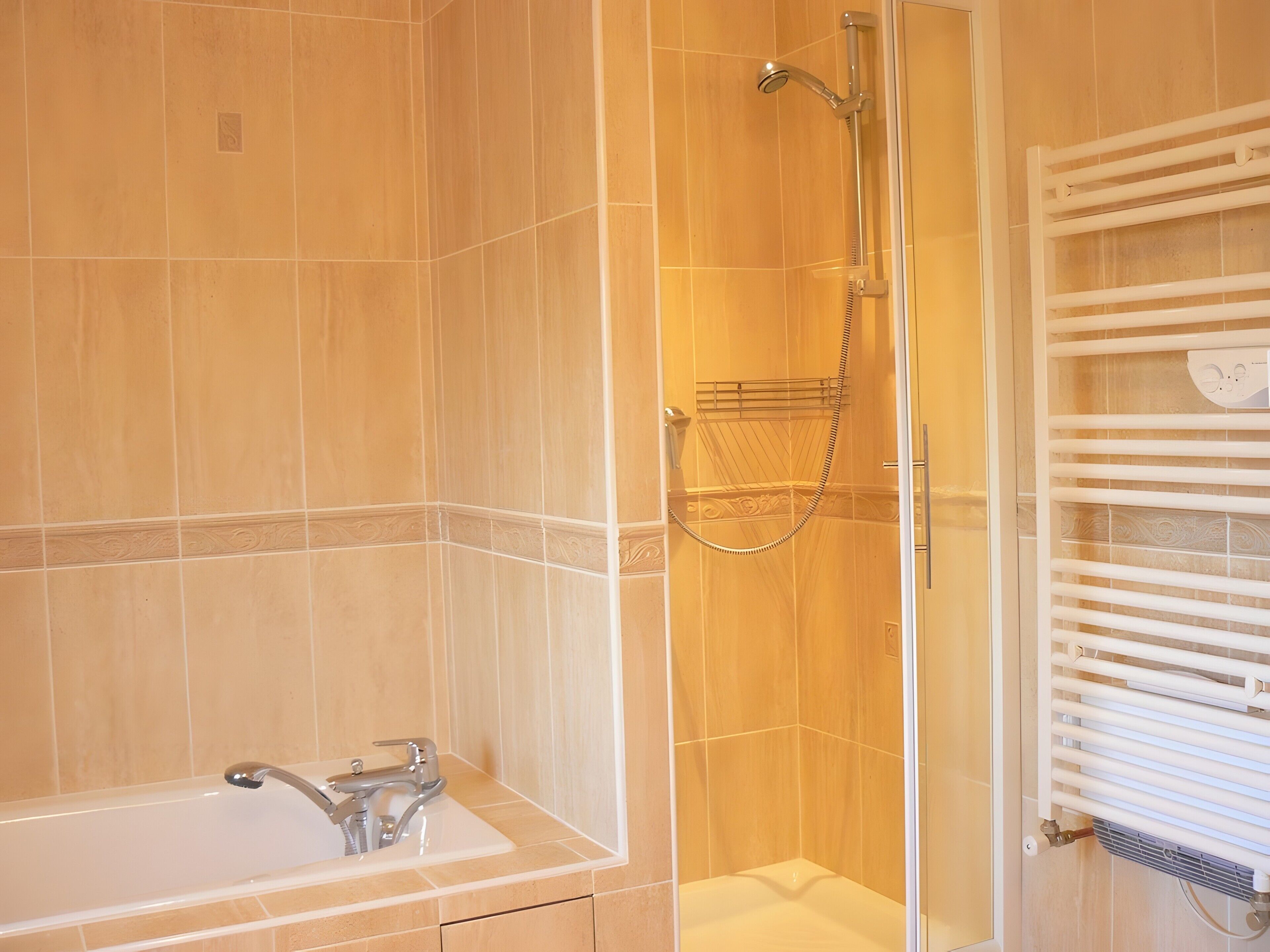 A bathroom with a bathtub, a shower, and a towel rack.