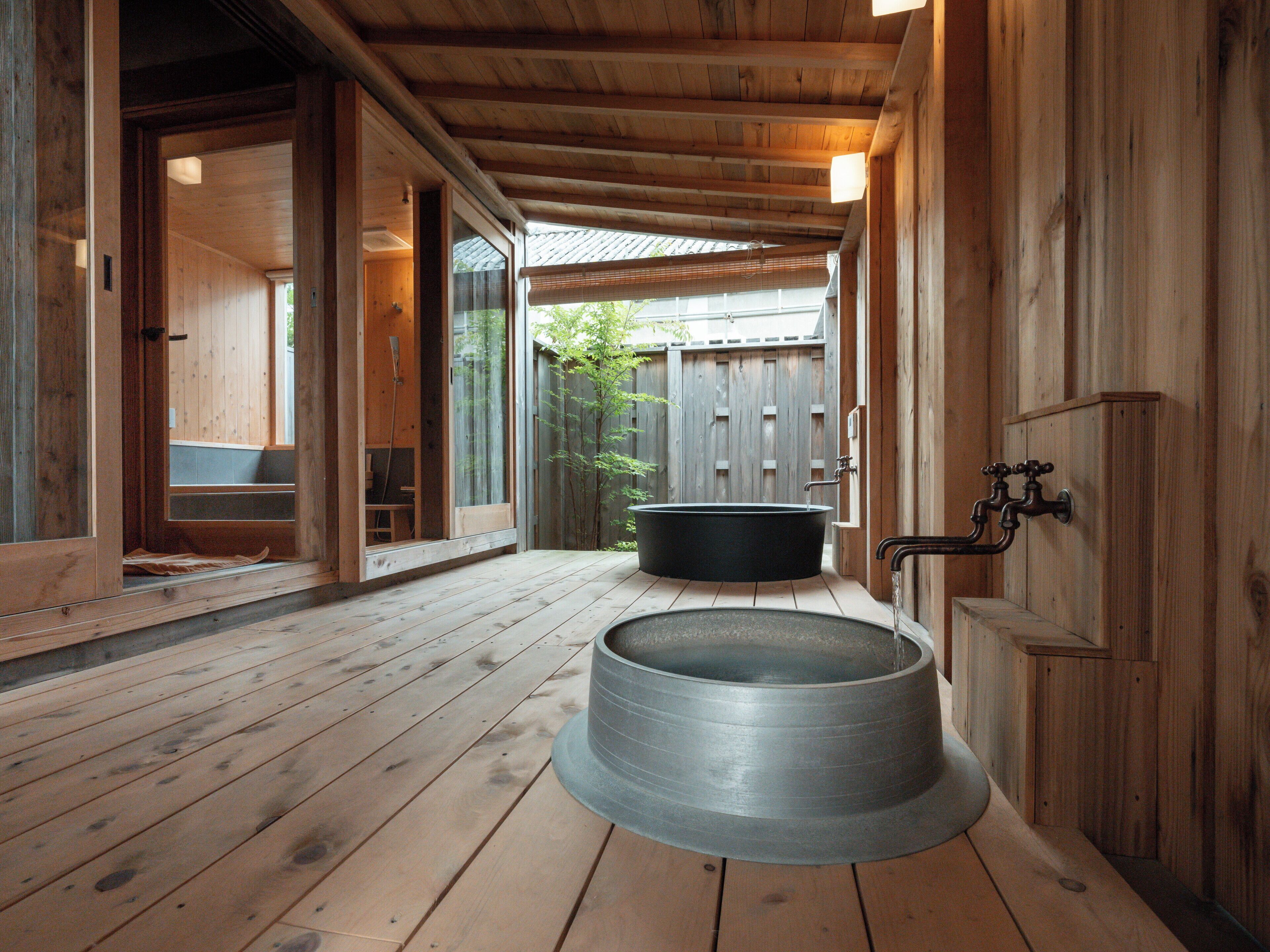 A wooden spa area with a large bathtub and a shower.