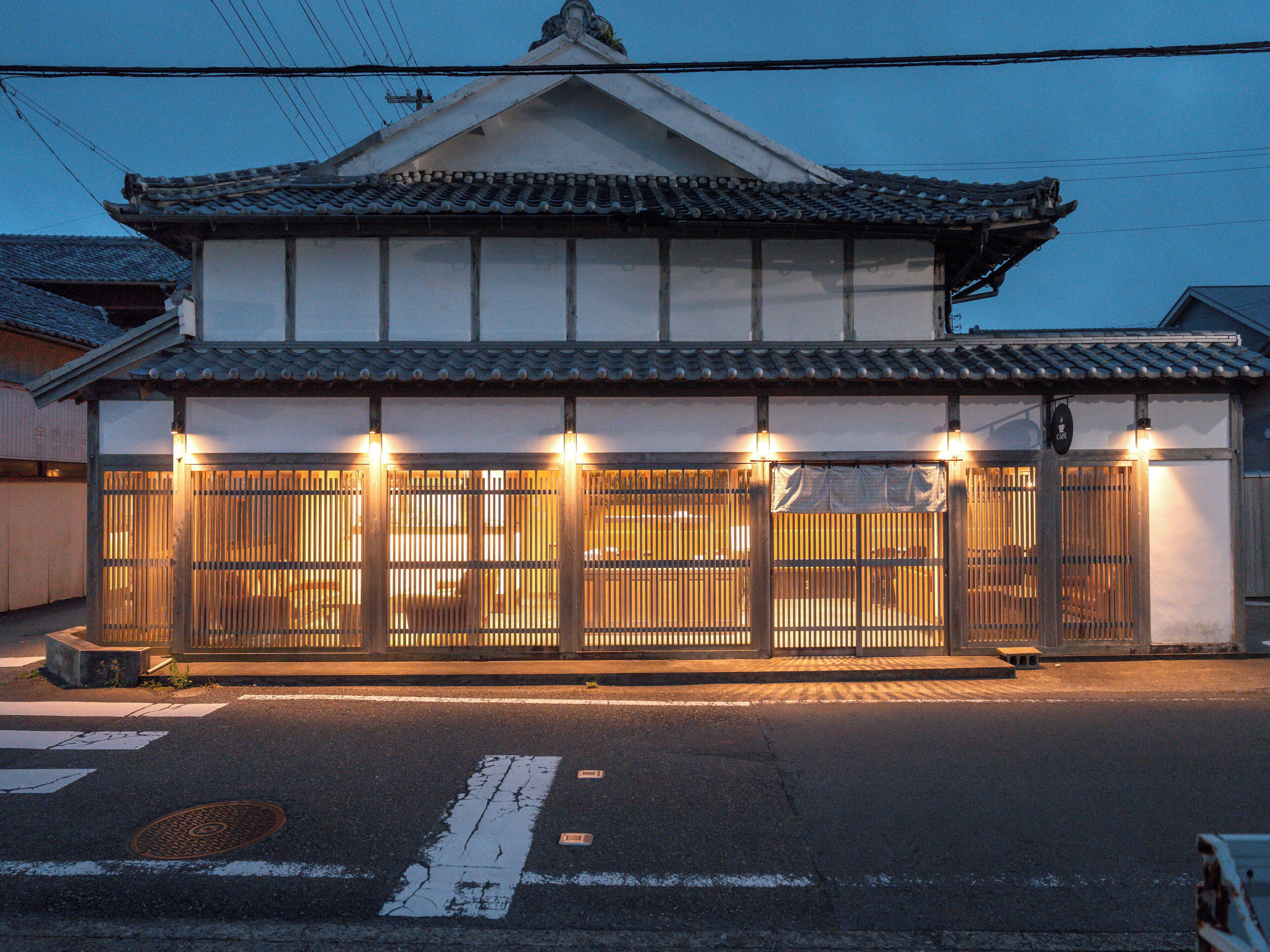 A traditional Japanese building with a tiled roof and a wooden gate.