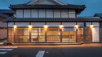 A traditional Japanese building with a tiled roof and a wooden gate.