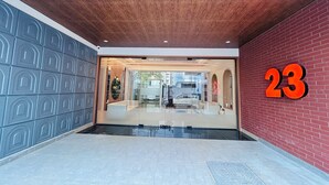 A modern building entrance with a glass door, a wooden ceiling, and a red brick wall. - Twenty Three Urban Square Madhapur (Hyderabad)