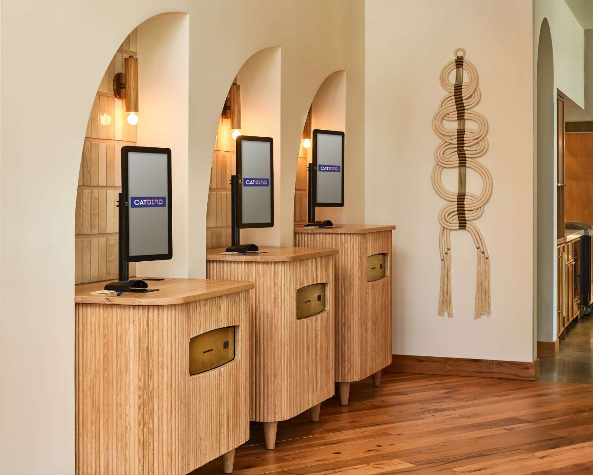 A reception area with wooden reception desks, each with a monitor and a 'CATBIRD' sign.
