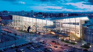 A modern building with a glass facade and a large sculpture in front. - Close to Coors Field + Kitchen. Bar. Playroom. (Denver)