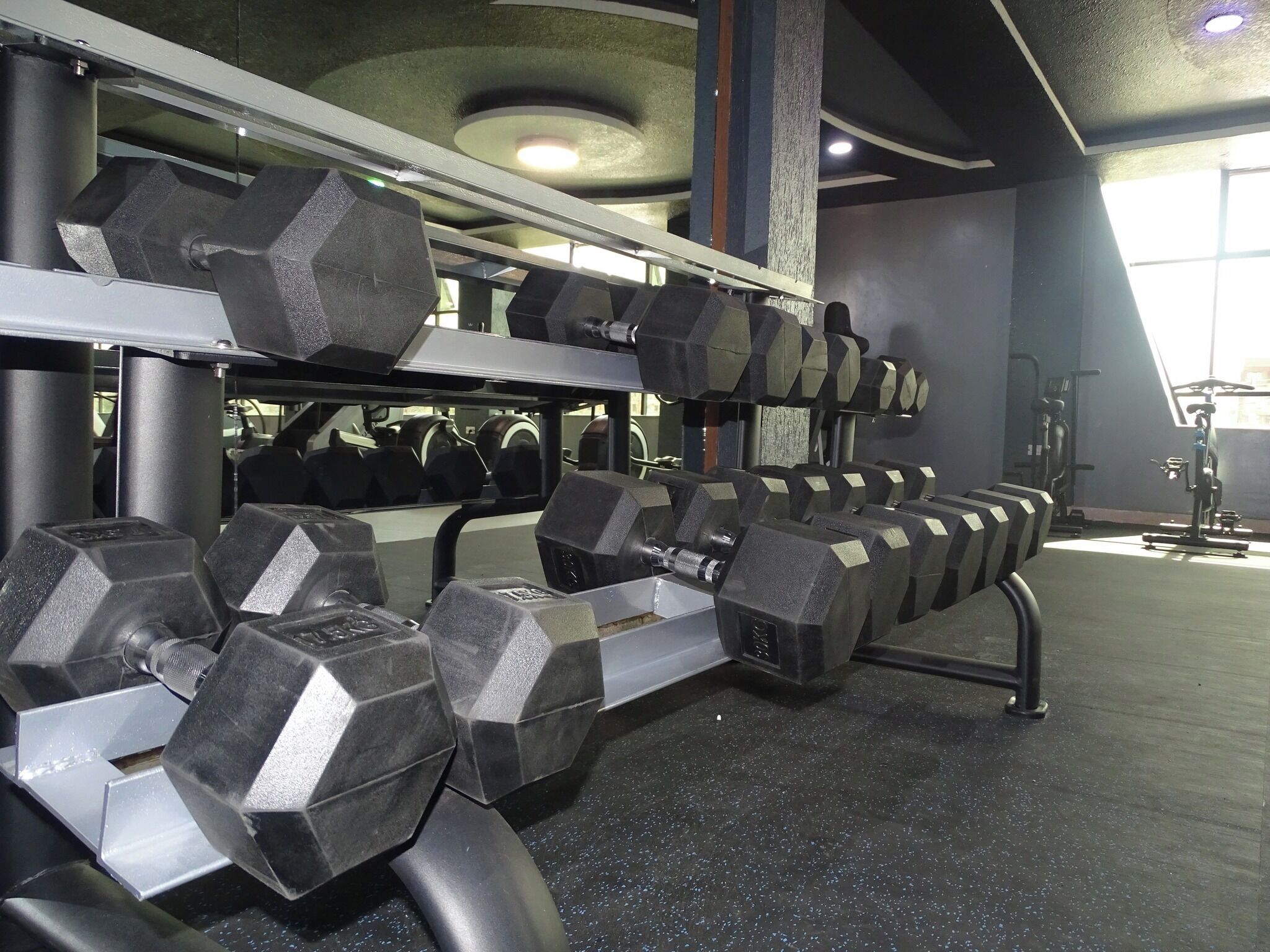 Ein Fitnessraum mit mehreren Stapeln sechseckiger Kurzhanteln.