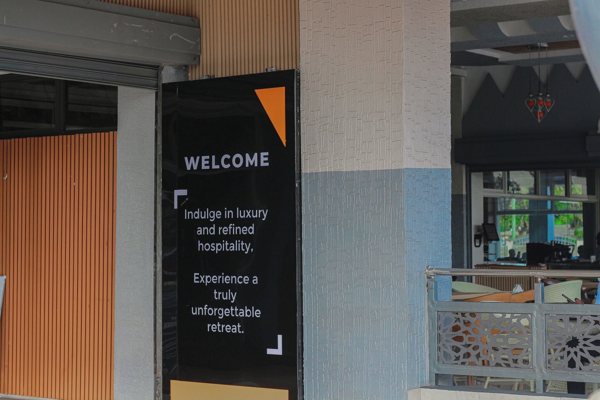A black welcome sign with white text inviting guests to indulge in luxury and refined hospitality, and experience a truly unforgettable retreat.