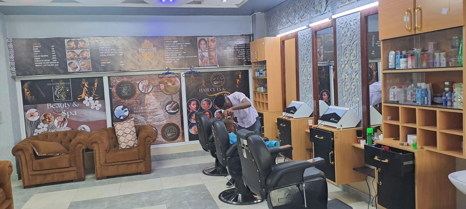 A hair salon with multiple chairs, a sofa, and a counter with various hair products.
