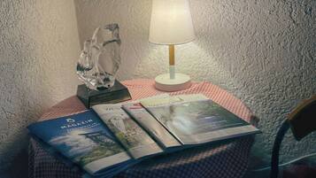 Ein Tisch mit kariertem Tuch, einer Lampe und einigen Zeitschriften.