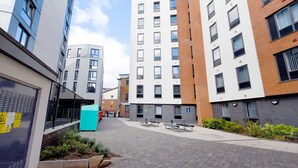 A modern urban building complex with multiple residential units, a pedestrian pathway, and outdoor seating areas. - For Students Only Newarke St (Leicester)