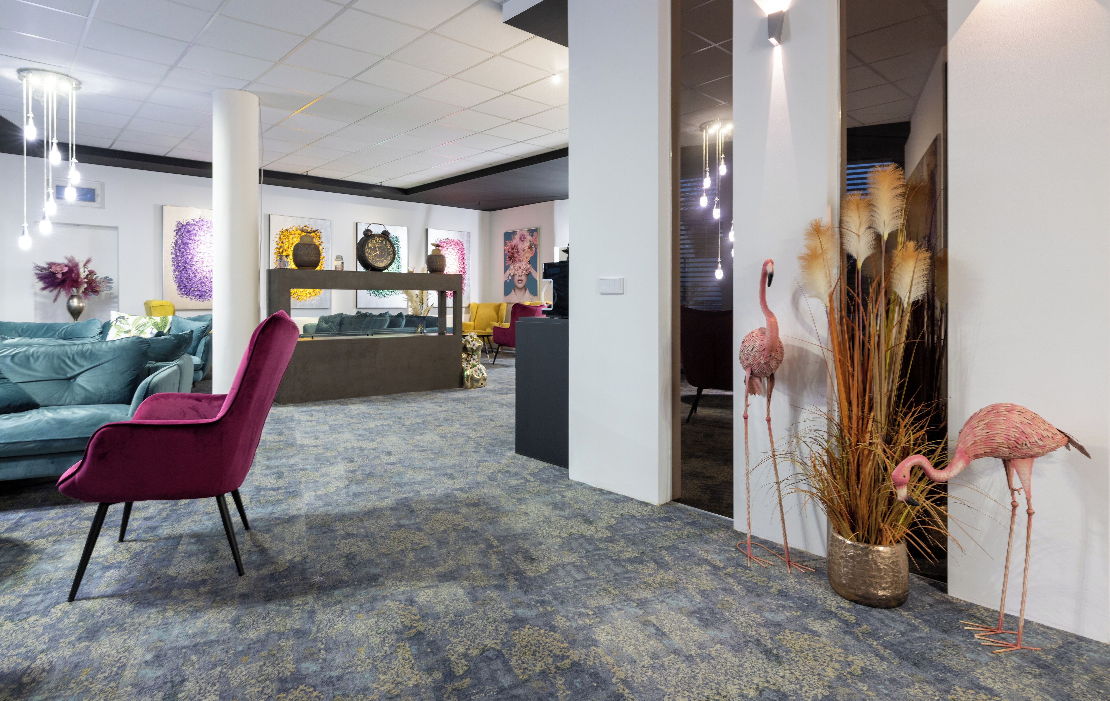 A modern lobby with a blue carpet, a purple chair, and a reception desk.