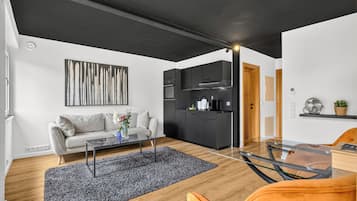 Ein stilvoller Wohnbereich mit Sofa, Couchtisch und Küchenzeile.