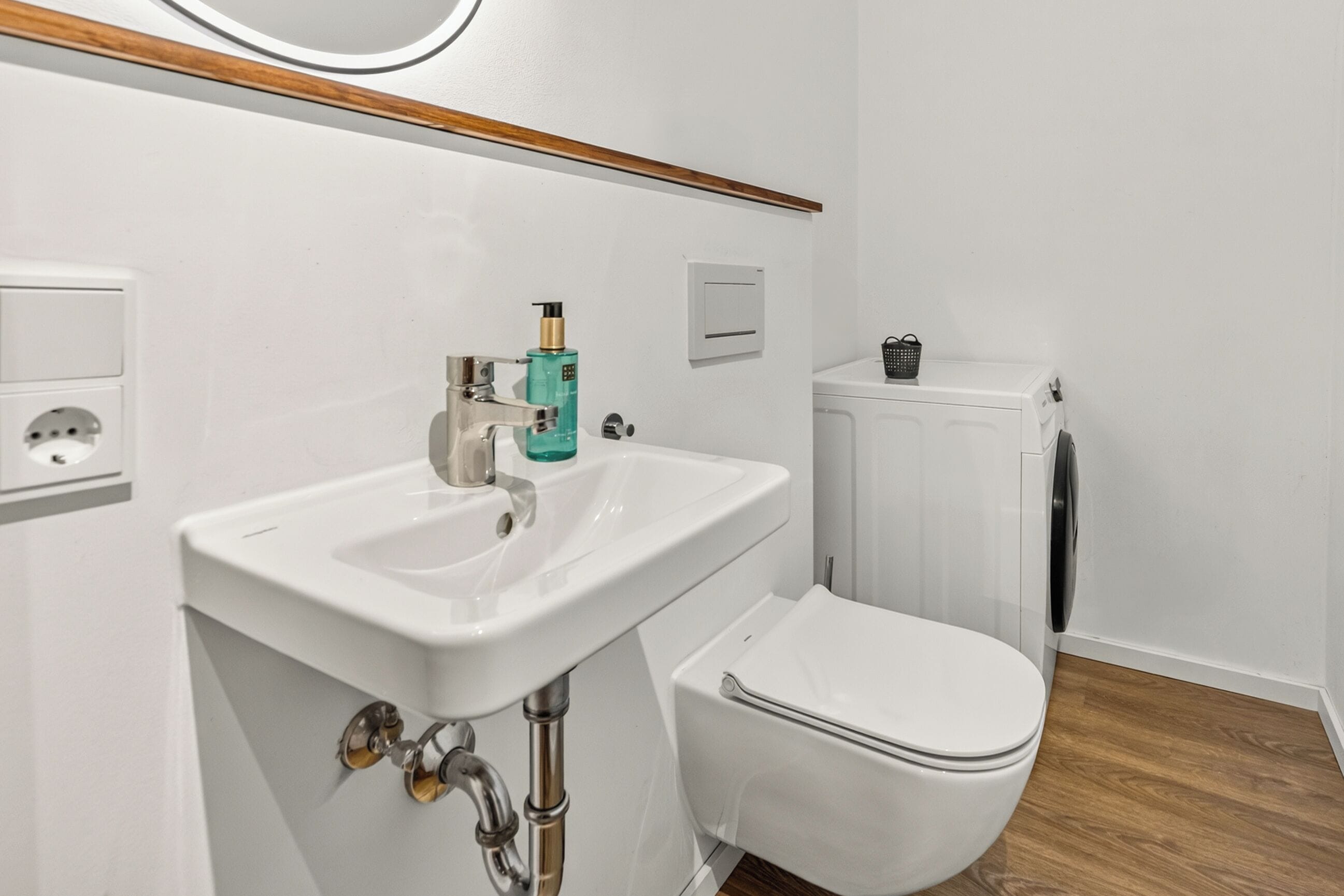 A bathroom with a white sink, a toilet, and a radiator.