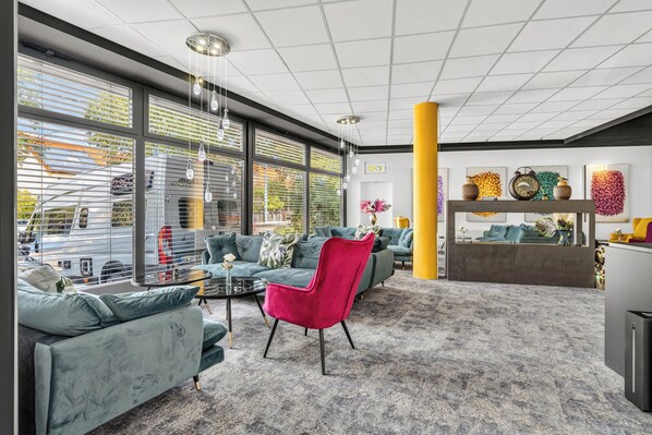 Un interior moderno con zona de estar, ventanas amplias y una pared decorativa.