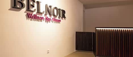 Un interior moderno con un letrero que dice "BEL NOIR Wellness Spa Fitness".