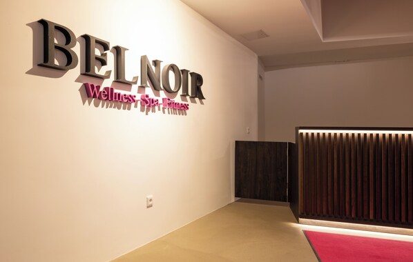 Un interior moderno con un letrero que dice "BEL NOIR Wellness Spa Fitness".