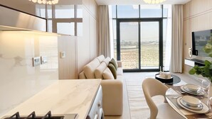 Una cocina moderna con estufa a gas, un comedor con una mesa para dos personas y un sofá.