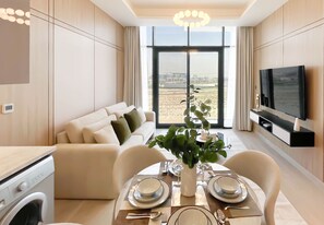 Uma sala moderna com área de jantar, sofá, televisão e vista para a cidade.