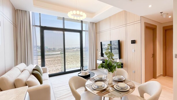 Una sala de estar moderna con un ventanal grande, un comedor con una mesa dispuesta para cuatro personas y una zona de estar con sofá.