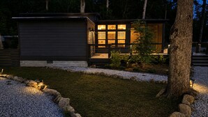 A modern house with a well-lit entrance and a gravel pathway.
