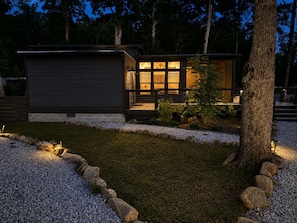 A modern house with a well-lit entrance and a gravel pathway.